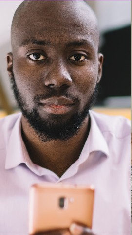 Portrait of a young man holding a phone